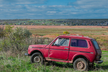 Red old car in nature. Rural landscape.
