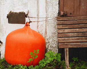 Big orange fender  chained to the wall.                              