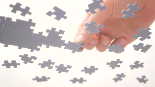 Bottom View. Human Hands Assembling Jigsaw Puzzle. Pastime, a hobby. Complex project management. Playing Calm Board Game. Unfinished Jigsaw Puzzle. Finding a Solution. Task and subtask concept