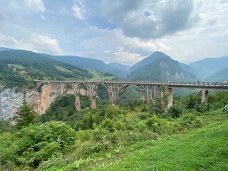 Panoramic bridge over the river surrounded by high mountains 