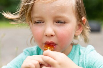 Little kid eating candy lollipop. Sweets and sugar.