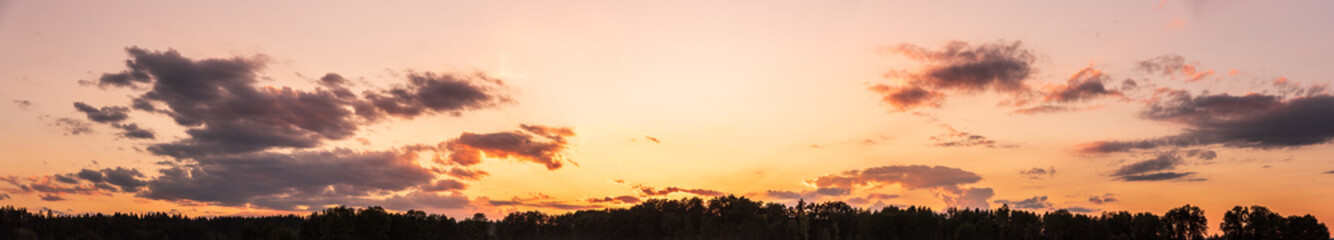 Panorama during sunset over forest with pastel colors sky and colorful clouds