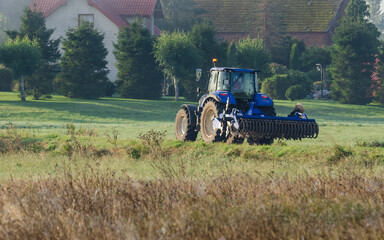 Fototapeta premium TRACTOR - The agricultural machine goes to work in the field