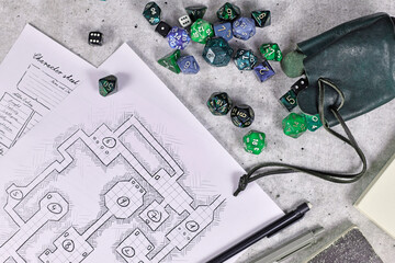 Tabletop role playing flat lay with RPG game dices, character sheet,dungeon map and pen on wooden...