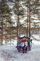 Fototapeta na wymiar Happy multiracial couple in white sweatshirts during a trip to the forest for the christmas tree.