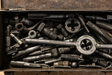 Old vintage iron toolbox full of drills and threading die tools as background