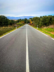 Lonely road to a green mountain landscape.