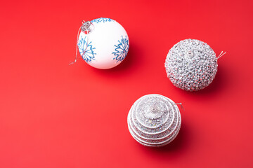 Christmas New Year composition. Gifts, silver and white ball decorations on red background. Winter holidays concept. Angle view