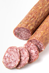 Dried sausage sliced into slices on a white plate. Elite meat product