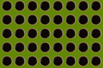 pattern with cups of black espresso coffee on olive green background