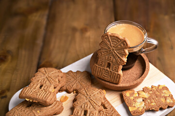 5th December holiday in the Netherlands. Speculaas koekjes and espresso for st. Nicolas day the background of festive garlands. Dutch holiday Sinterklaas traditional sweets gingerbread cookies. 