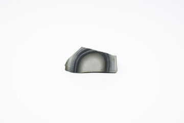 Striped flint stone isolated on a white background. Amazing curves and stripes. Grey colors and amazing lines
