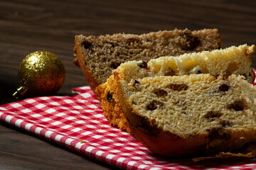 Slices of panettone and chocolate panettone with Christmas decorations and seletive focus