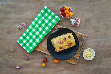 Portion of lasagna on wooden surface. Concept of gastronomy.