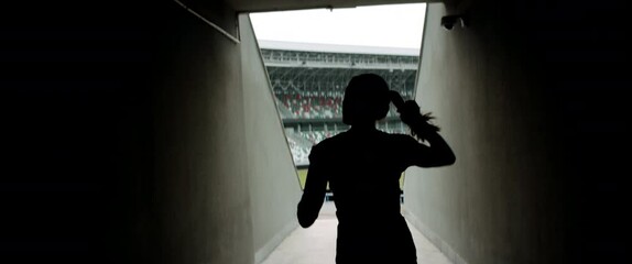 HANDHELD TRACKING Caucasian female athlete entering stadium before morning training. Shot with anamorphic lens - Powered by Adobe
