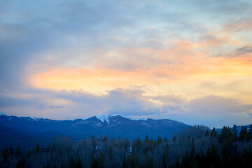 Naklejka na ściany i meble Snow capped mountain landscape at sunset near forest in Apraho National Forest, Colorado