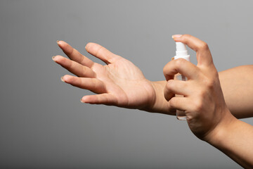 Mixed race person using hand sanitizer