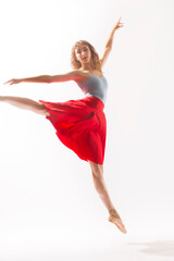 Ballerina in red skirt leaping against a white background.