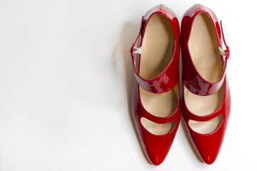 Beautiful red female dress shoes on a white background, top view.