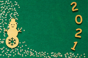 Fototapeta premium Happy New year 2021 celebration. Gold wooden numbers 2021 and gold confetti on green felt background. Flat lay with space for text