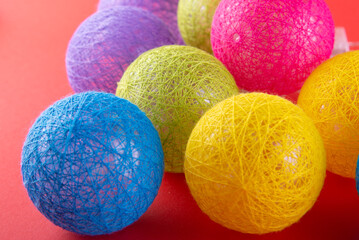 Different collor big knitted balls on red background