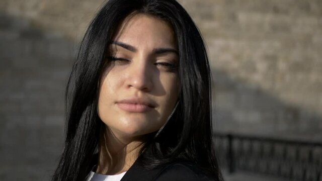 brunette girl in black walk in old town in sunny day portrait video