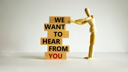 Wooden blocks with text 'we want to hear from you'. Wooden model of human. Beautiful white...