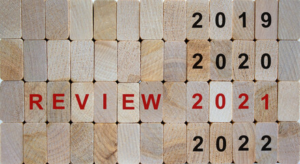 Business concept of planning 2021. Wooden blocks with the inscription 'Review 2021'. 2019, 2020, 2022 numbers. Beautiful wooden background, copy space.