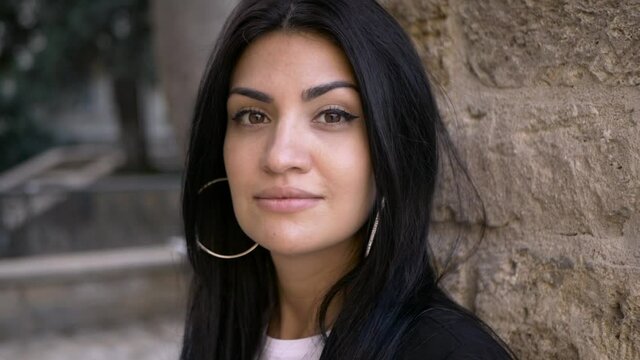 brunette girl in black walk in old town in sunny day portrait video