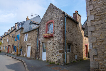 Fototapeta na wymiar Dinan, France - August 26, 2019: Old street with stone medieval houses in the historic town centre of Dinan, French Brittany
