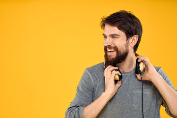 Man in headphones listens to music technology lifestyle fun people yellow background