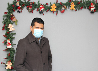 Latino man with protection mask and Christmas decoration, new normal covid-19