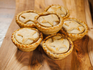 Fresh mince pies on a wooden board. Traditional Christmas pastry product.