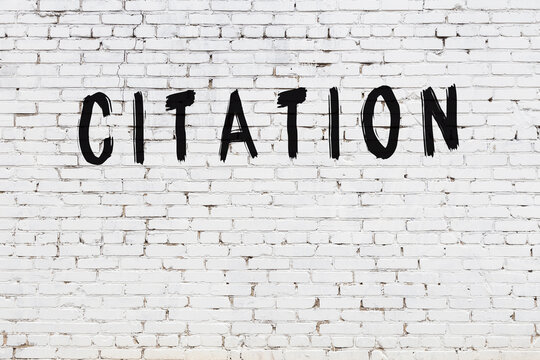 Inscription citation painted on white brick wall