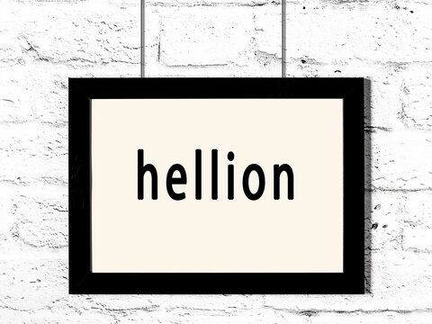 Black frame hanging on white brick wall with inscription hellion