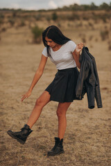A photo session with a young lady dressed in black in nature, in the background is a brown chain