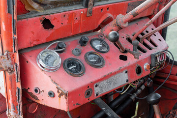 Closeup dashboard gages of old rusty red russian tractor during autumn harvest agriculture technology transportation vehicle