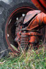 Close up of shock absorb sprint on tractor front tire rare unique red rusty russian vehicle agriculture autumn outdoor