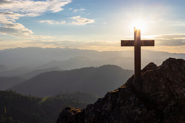 Silhouettes of crucifix symbol on top mountain with bright sunbeam on the colorful sky background - Powered by Adobe