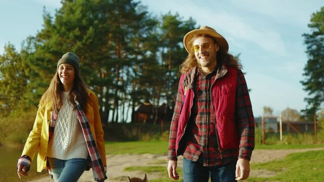 Close up hipster friends met eath other in nature. Four young people hug smiling with dog at sunlight. Vacation tourism adventure outdoors. Slow motion