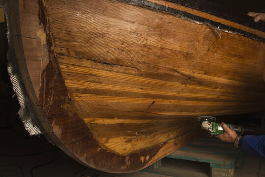 hull of a traditional Galician boat called Dorna. the boat builder is polishing it