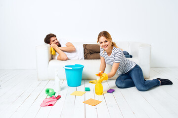 young couple at home near sofa washing supplies cleaning lifestyle