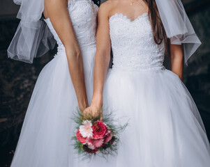 Fototapeta na wymiar Newlywed lesbian couple on their happy wedding day wearing white dresses. Equality concept.