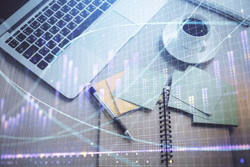 Stock market graph and top view computer on the table background. Double exposure. Concept of financial education.