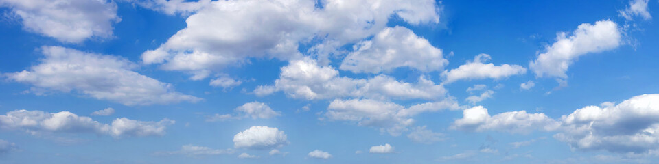 Ultra wide panorama of afternoon blue sky with white clouds.