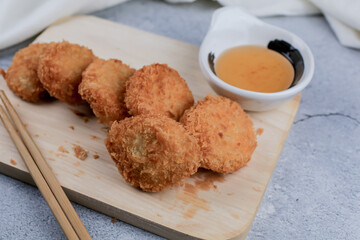 Shrimp pancake with dipping sweet sauce on wooden cutting broad. Food Asian style Served with Sweet plum Sauce. Tod Mun Goong.