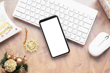 Mockup blank white screen smartphone on home office desk background for Christmas and New Year background concept, Flat lay top view with copy space for your Merry Christmas and Happy New year artwork