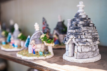 Small souvenirs by the traditional trulli houses in Arbelobello, province Bari, region Puglia,...