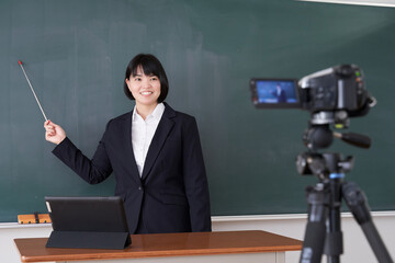 教室でオンライン授業の撮影をする日本人女性教師