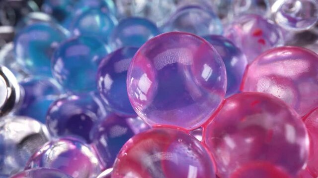 Macro view of glass spheres wet with red and blue paint, abstract background 4k, blue vs red reflections